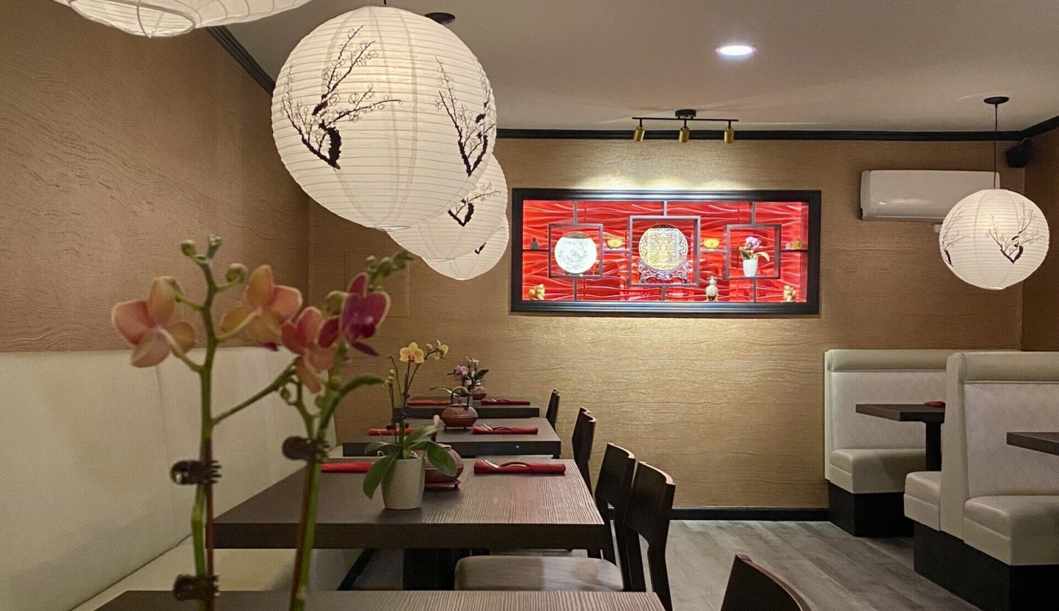 interior dining room with four black tables and traditional Chinese decor and design with red and black colors