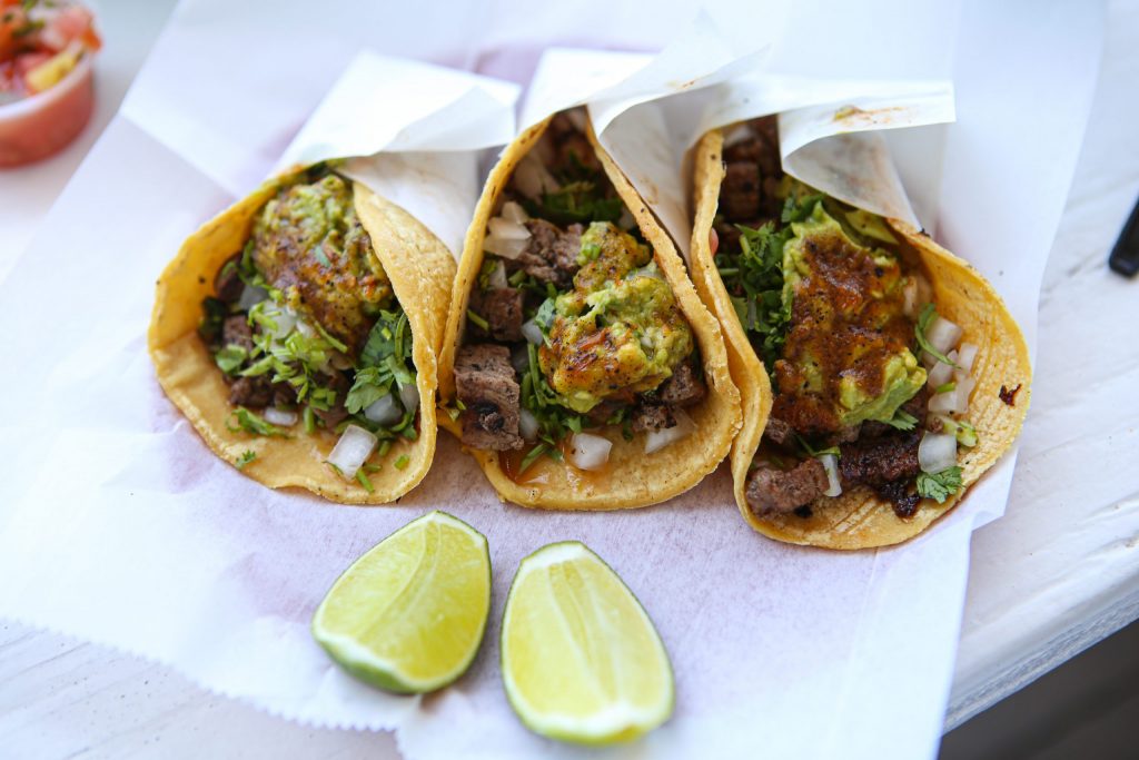 three tacos with meat, onion, cilantro, guacamole, and two lime slices from the taco stand in La Jolla