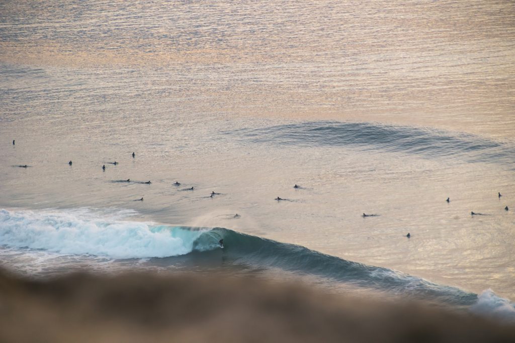a group of surfers are scattered waiting for the next set of waves at blacks beach, one of the top La Jolla beaches 