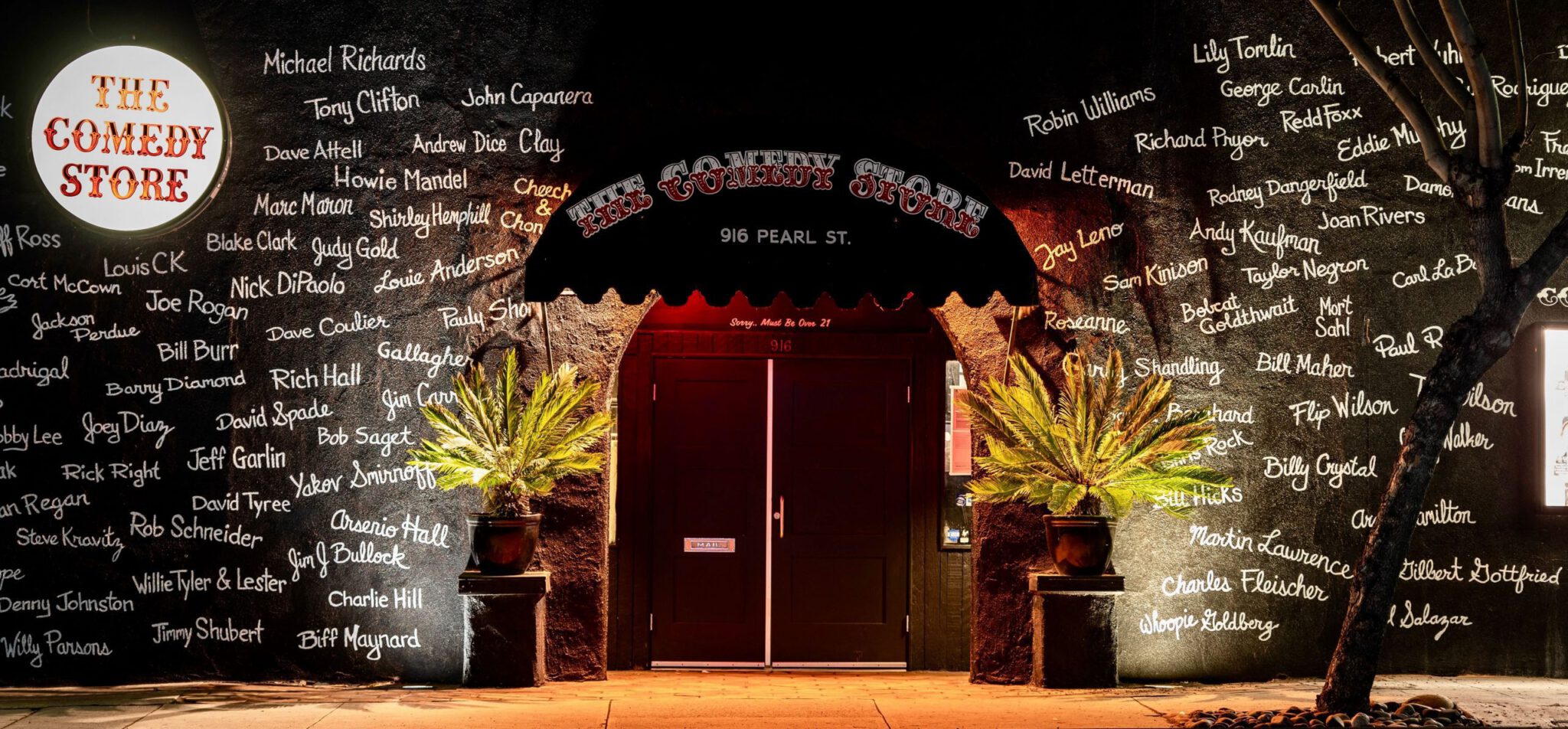 outside view of the front of the comedy store in La Jolla, a black building covered with the names of great comics in white