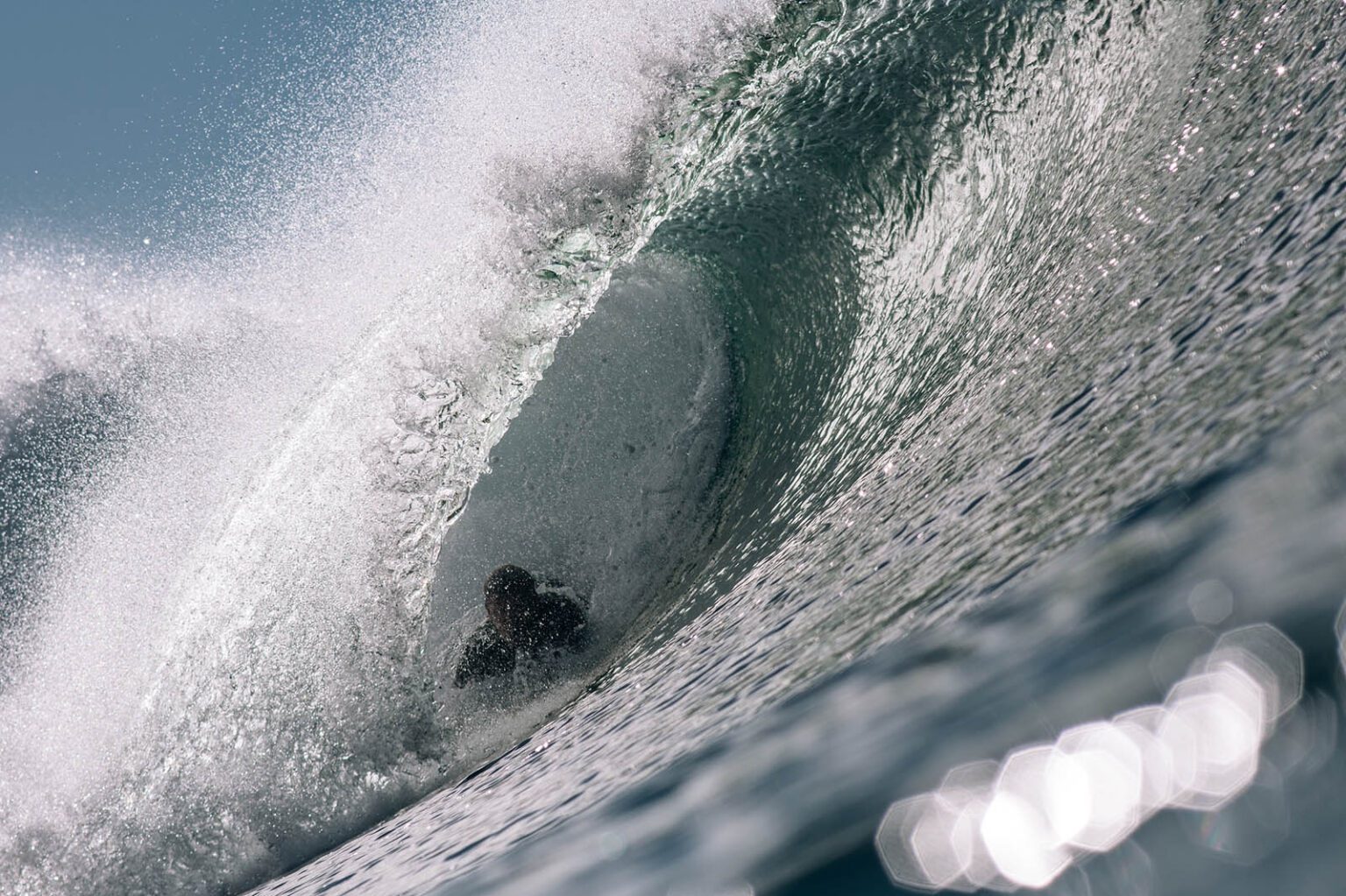 Color photograph of Chris Keeney bodysurfing inside a waves barrel in La Jolla California