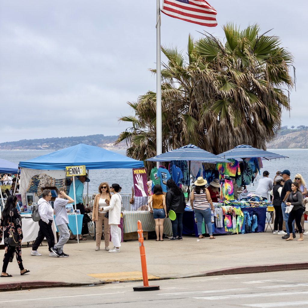 crowd of tourists shop from sidewalk vending tents as sidewalk vending enforcement needs further clarification