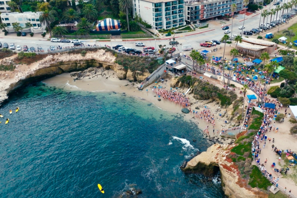 aerial drone view of blue watered La Jolla cove as the La Jolla cove swim commences with swimmers at the ready