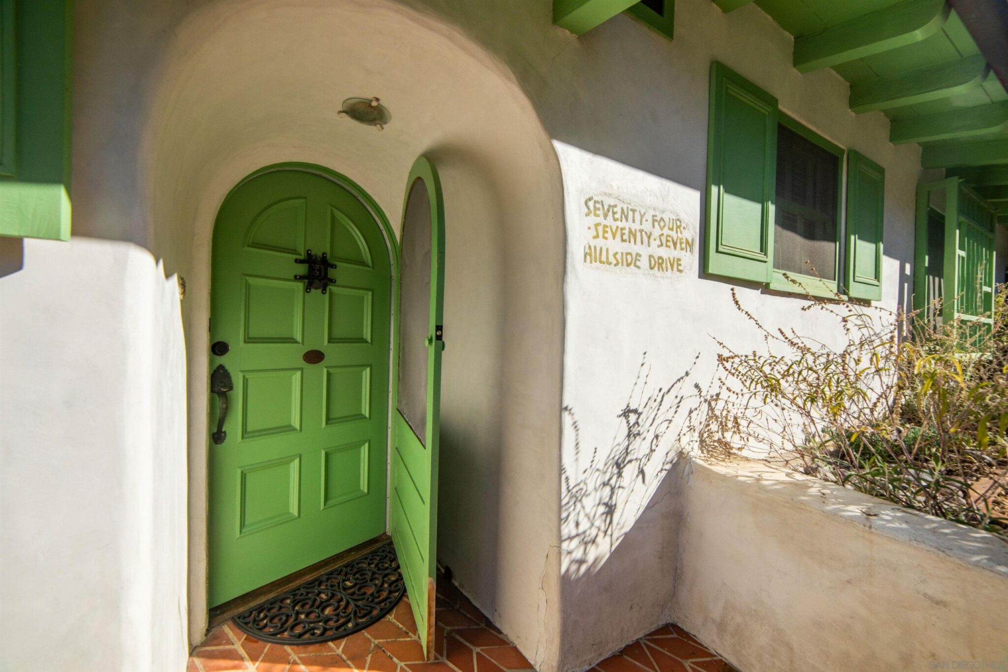 curved green entry door to the munchkin house in La Jolla