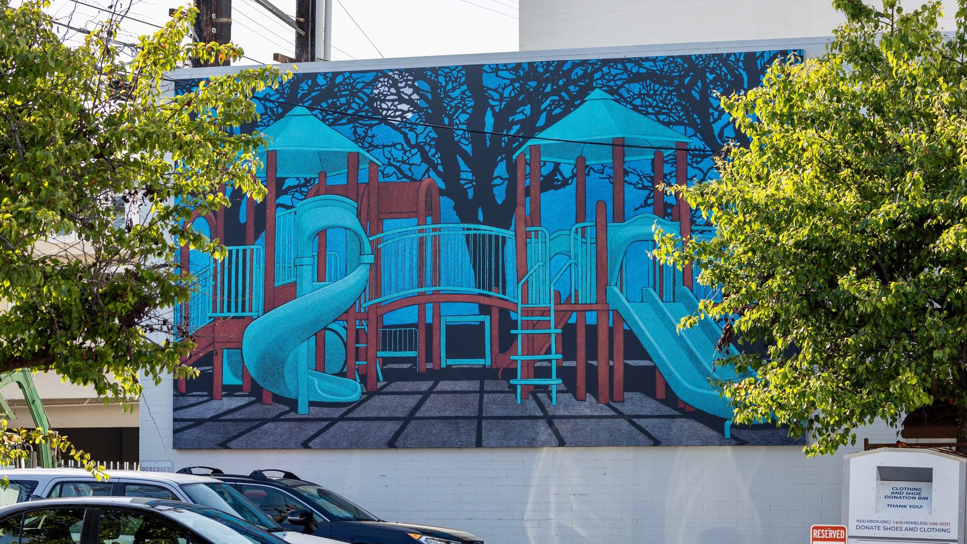 mural by Amy Adler installed on side of building is life size painting of a childrens playground