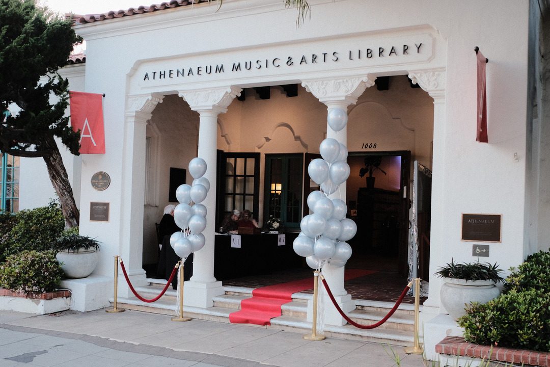 entrance to athenaeum music & arts library In La Jolla for athenaeum's 'talk of the town' event, red carpet is draped down the front 3 steps with silver balloons on each side of pillared entrance